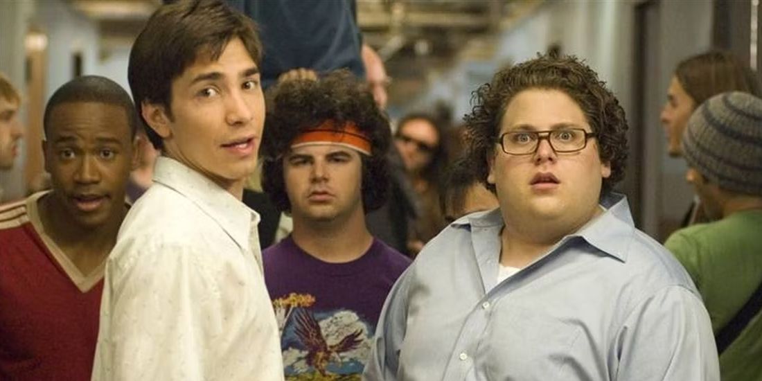 Plusieurs jeunes hommes regardent quelque chose dans le film Accepted.