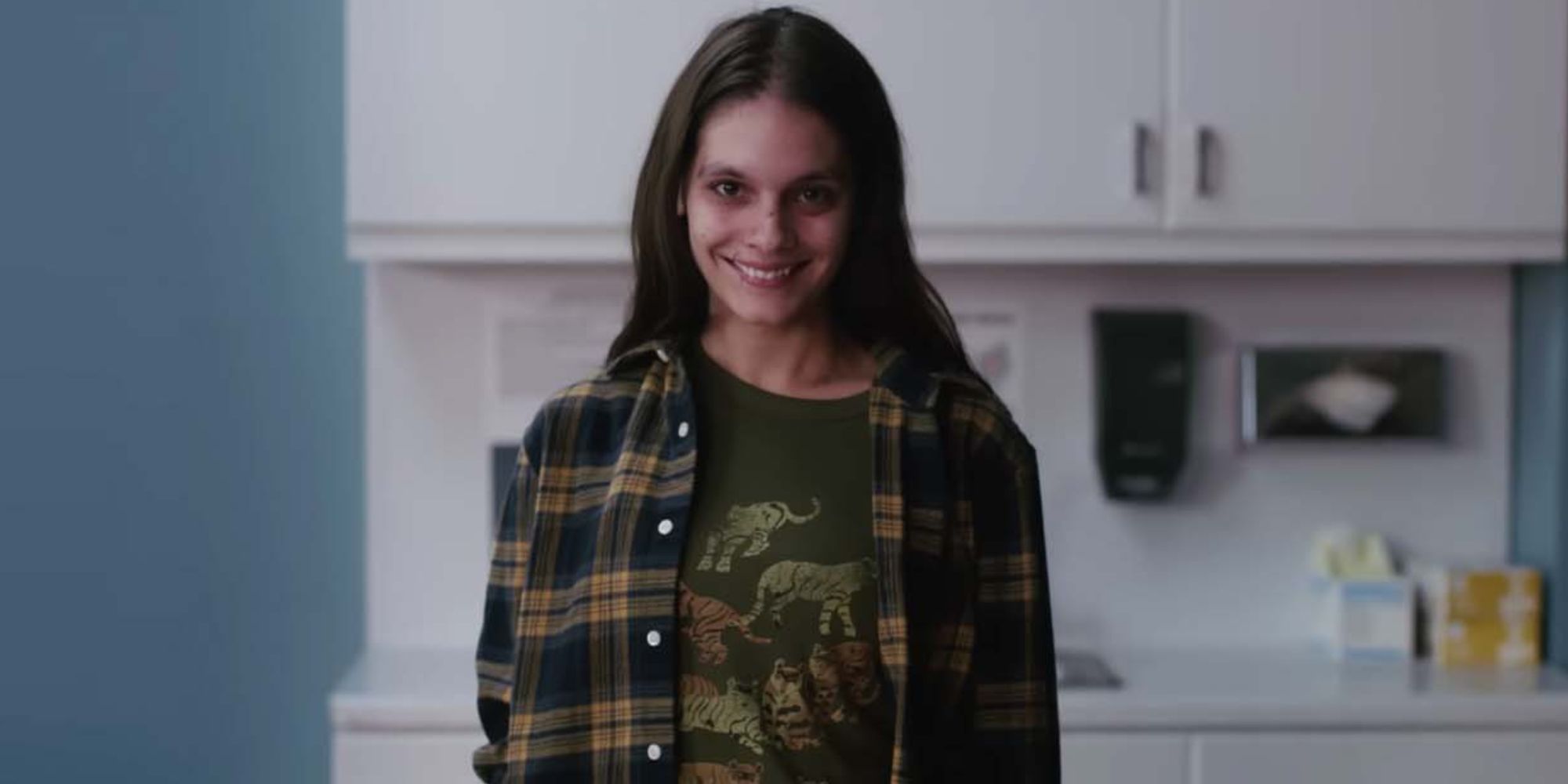 Caitlin Stasey dans le rôle de Laura, une femme qui sourit de manière effrayante à la caméra, de Smile (2022)
