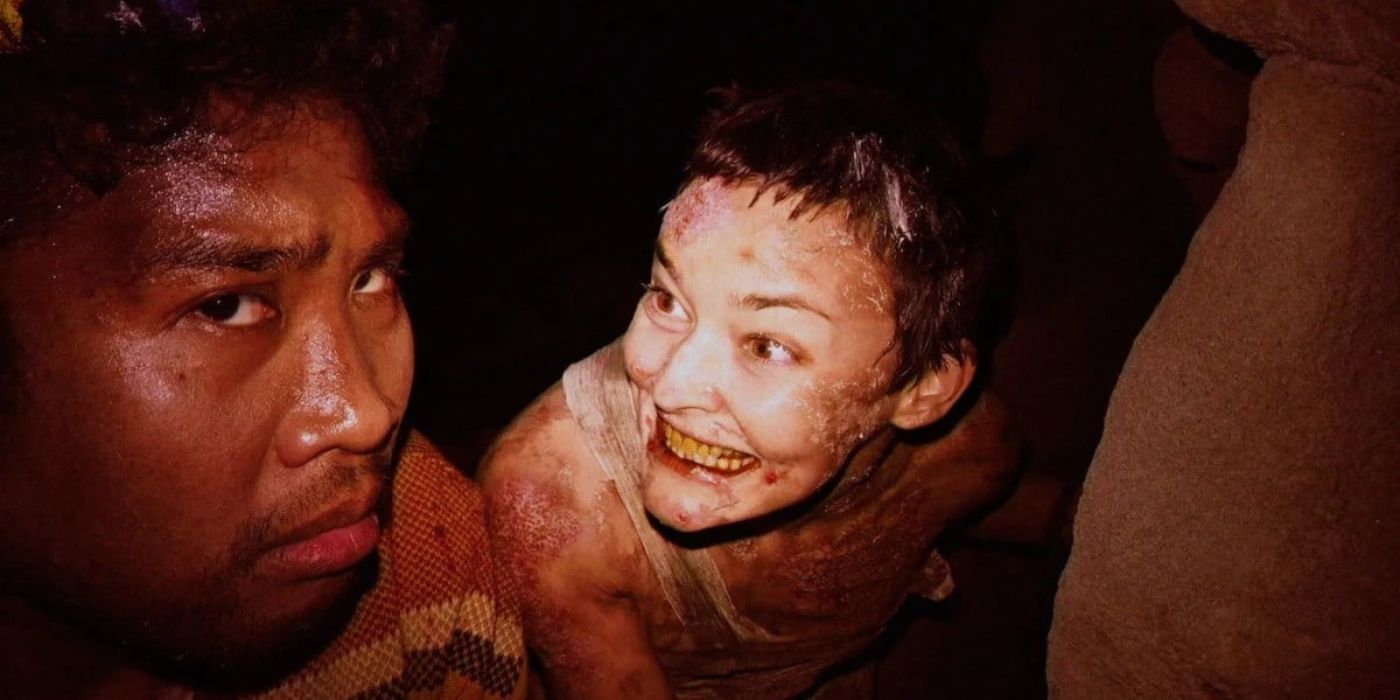 Une femme effrayante souriant à un homme regardant avec inquiétude le quatrième mur dans V/H/S/99