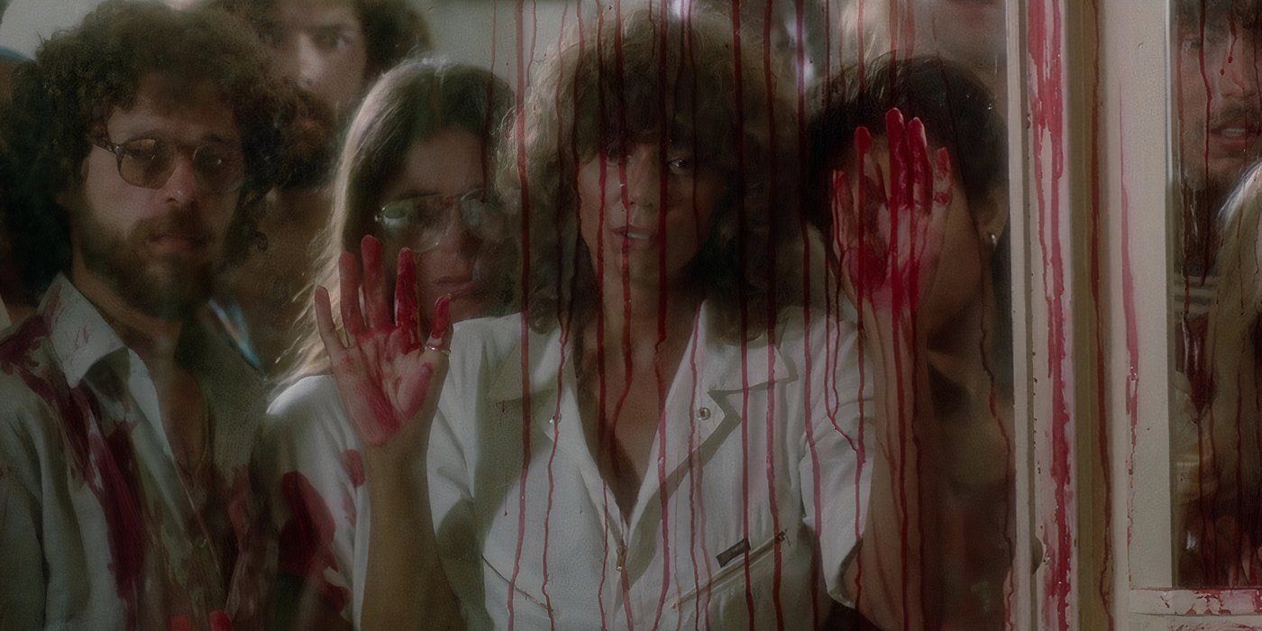 Foule derrière une fenêtre ensanglantée dans « Piranha II The Spawning »