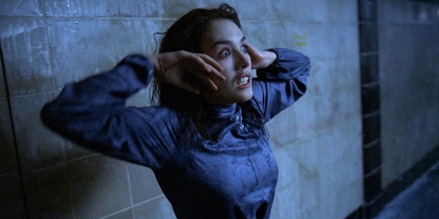 Anna dans une robe bleue touchant son visage, l'air terrifiée dans Possession de 1981.